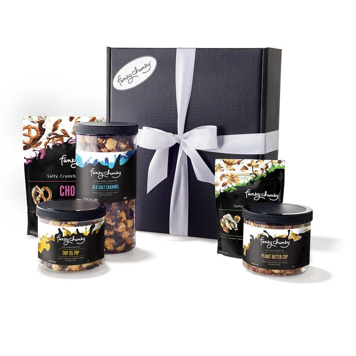 Funky Chunky Supreme Gift set featuring assorted gourmet popcorn and pretzel snacks in jars and bags, including Sea Salt Caramel, Chip Zel Pop, and Peanut Butter Cup, elegantly packaged in a black gift box with a white ribbon.